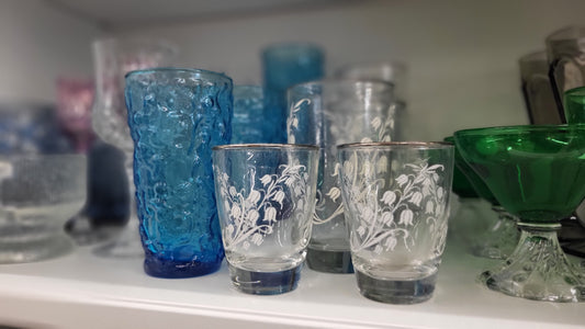 Vintage antique shop shelves filled with nostalgic treasures, glassware, frames, and old-soul home decor