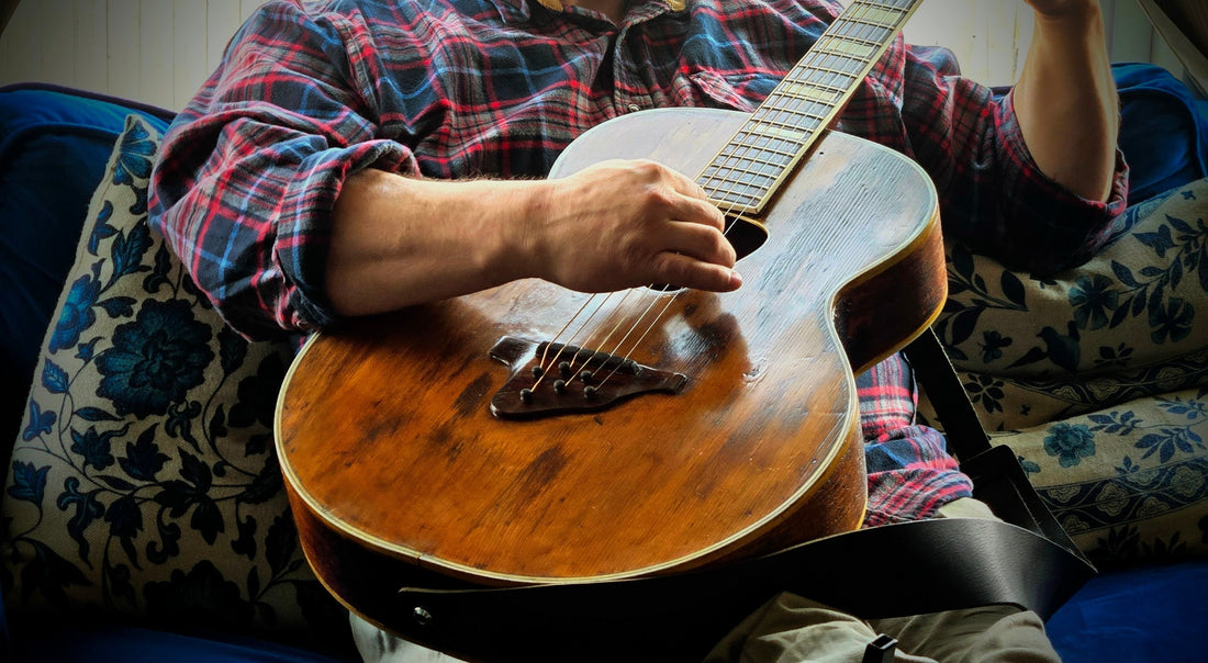 Vintage acoustic guitar being played, representing meaningful Father’s Day gifts for dads who love music and old-soul memories.