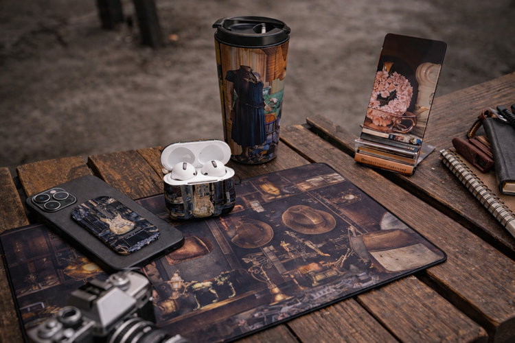 Vintage tech accessories on rustic wooden table including phone case, AirPods case, travel mug, phone stand, and desk pad